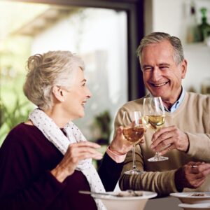 Toasting their golden years. Shot of an elderly couple enjoying a meal and wine together at home.